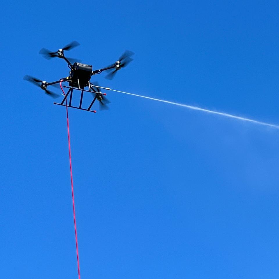Drone performing the cleaning process with the high-pressure washing system.